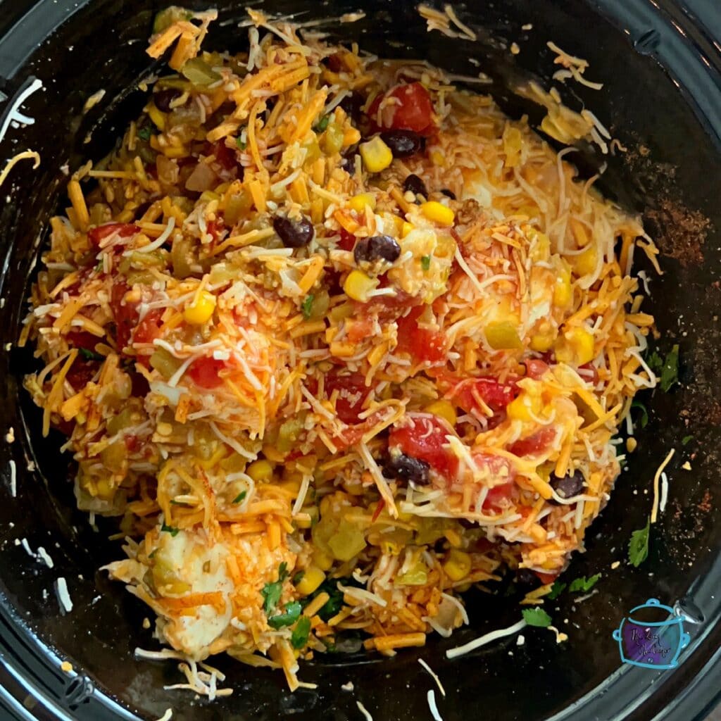 all fiesta dip ingredients in slow cooker stirred and ready to cook