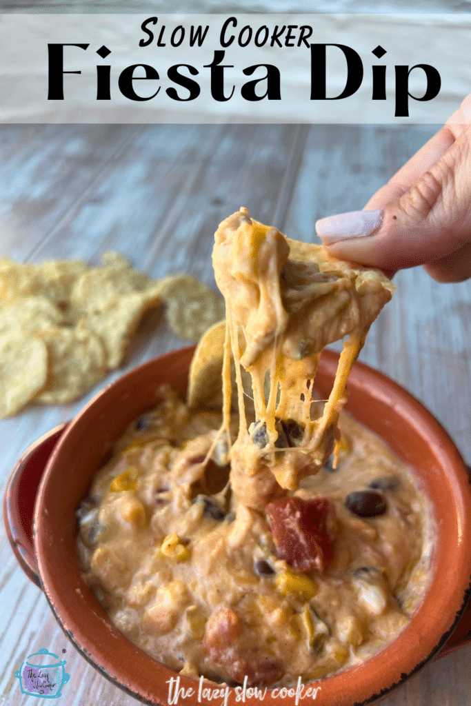 gooey cheesy dip being held up on a tortilla chip