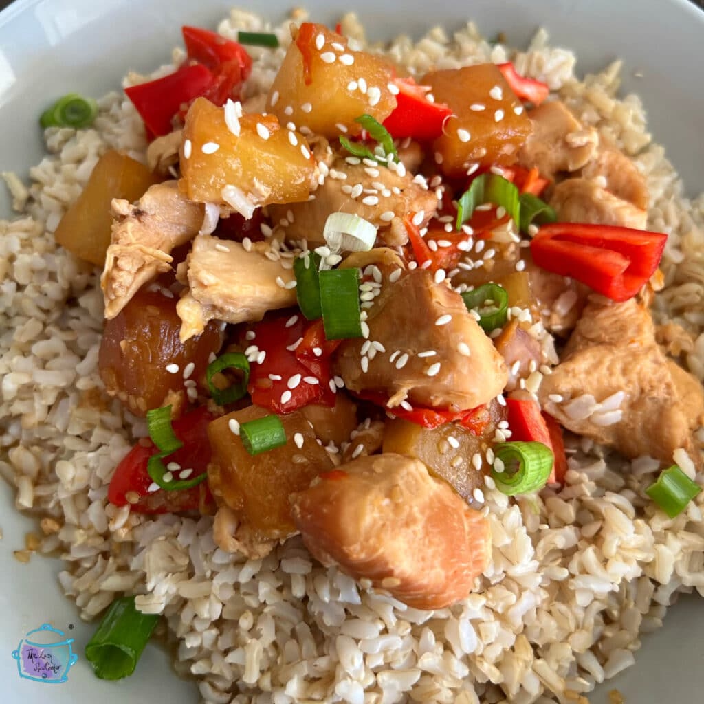 chicken with pineapple and red peppers plated over rice