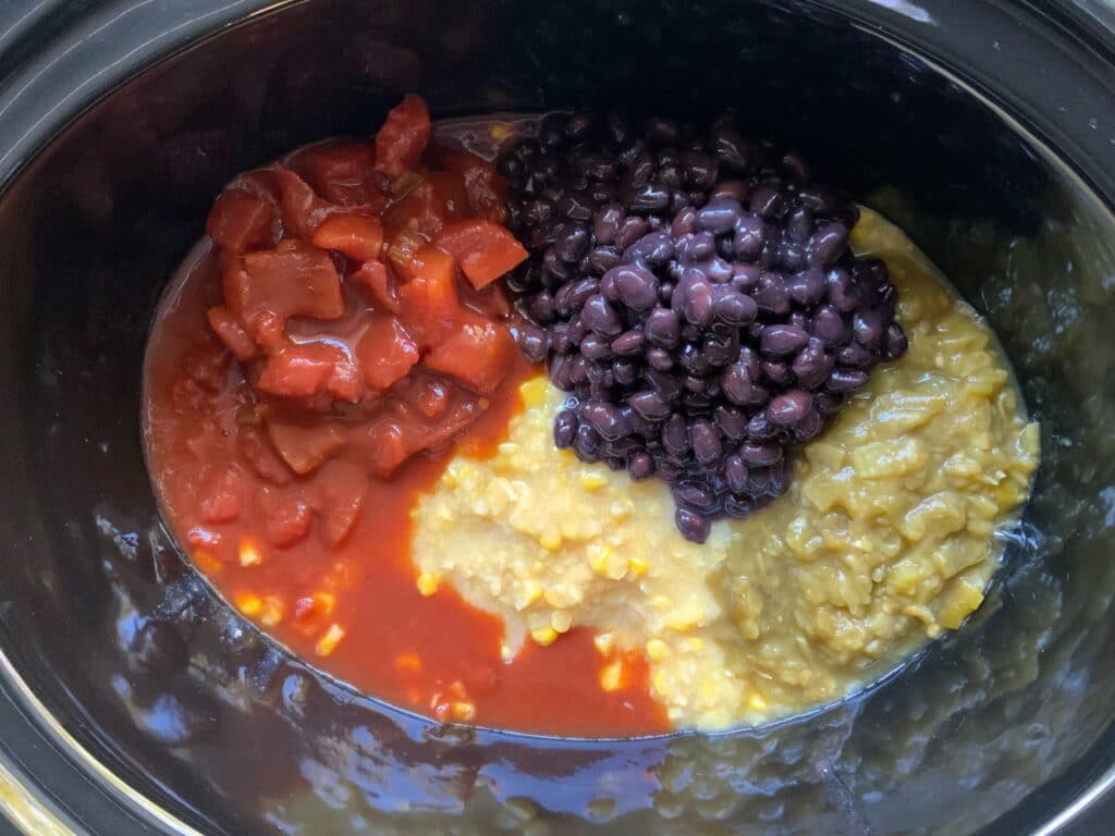 beans tomatoes and corn in a slow cooker getting ready to make vegan sopu
