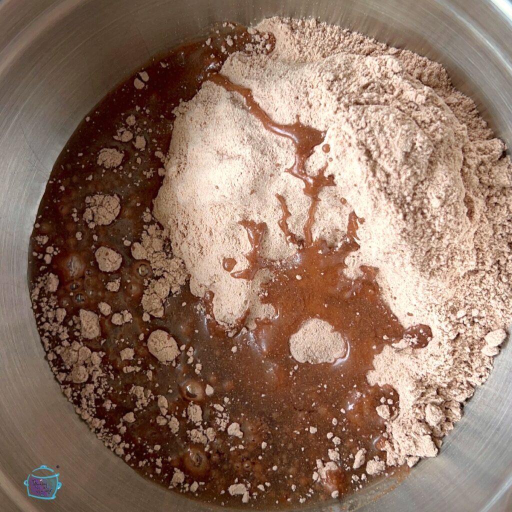 Raw brownie ingredients being mixed together in a bowl.