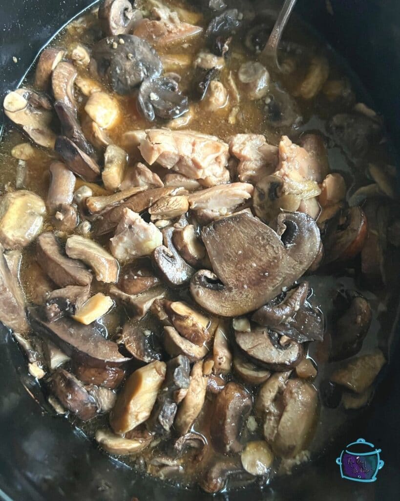 mushrooms and chicken pieces in crockpot before serving