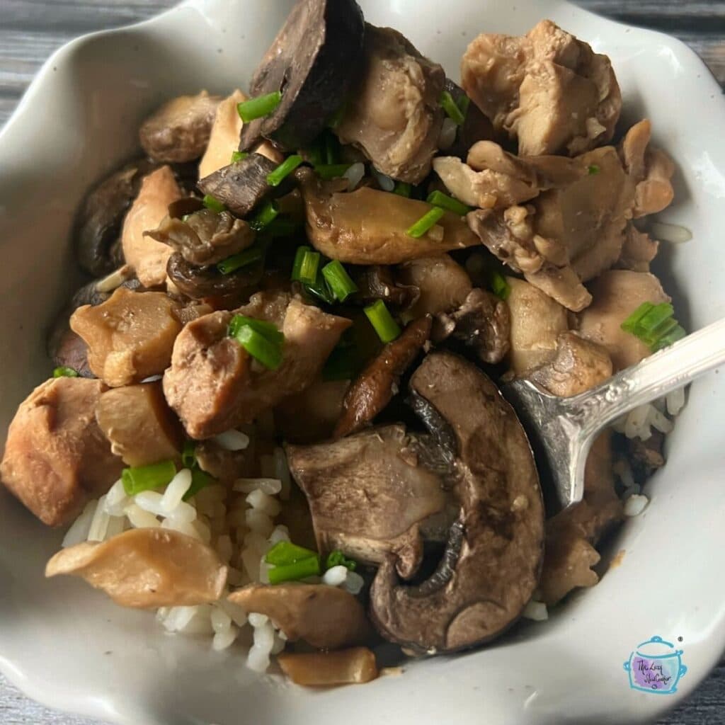 braised chicken and mushrooms with a white bowl with a spoon