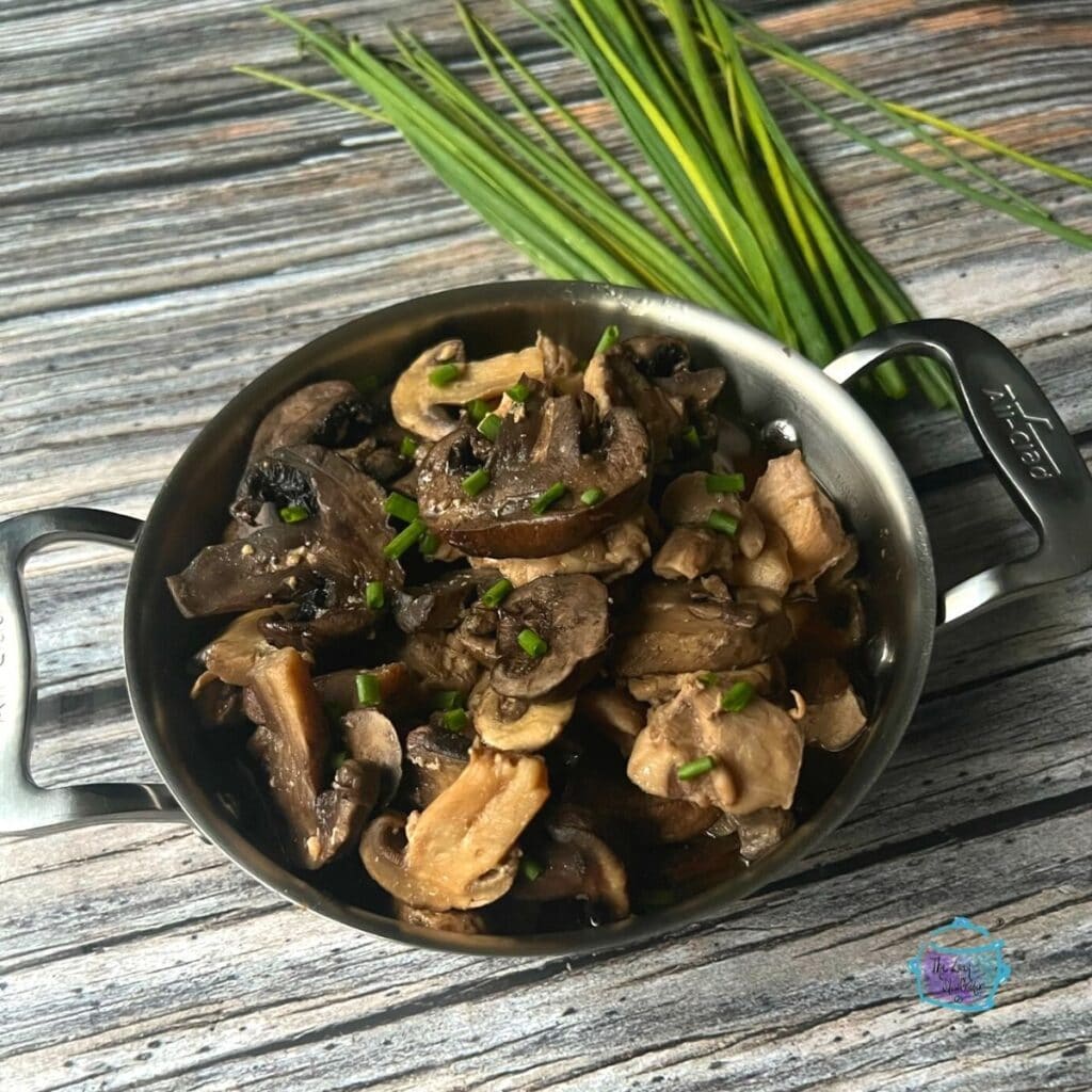 side view of a metal pot filled with slow cooker chicken and mushrooms
