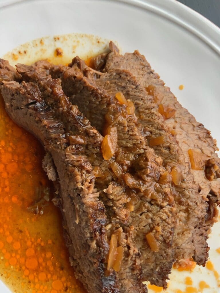 brisket slices on a plate with juice
