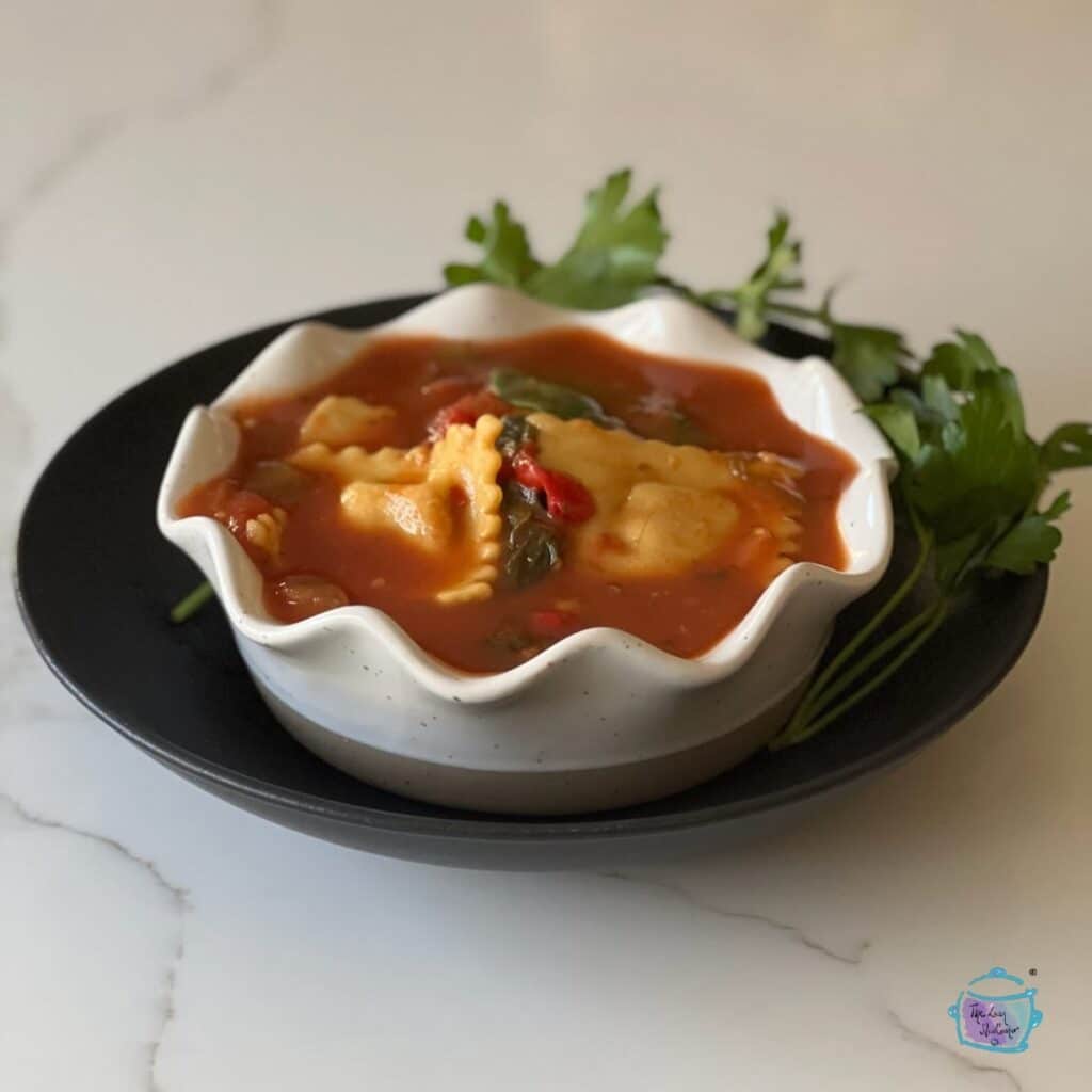a white bowl filled with ravioli and soup