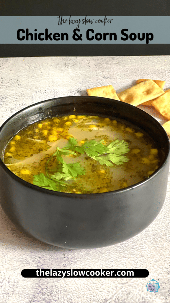 side view of chciken and corn soup with some fresh basil floating on top as garnish