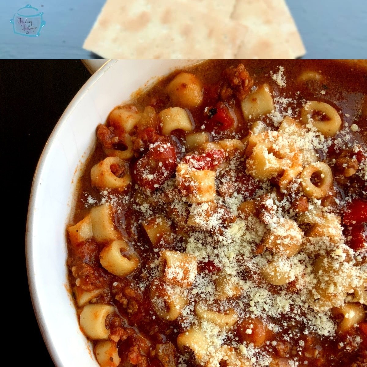 Close up of a bowl of pasta e fagioli with grated parmesan cheese on top in a white, round bowl