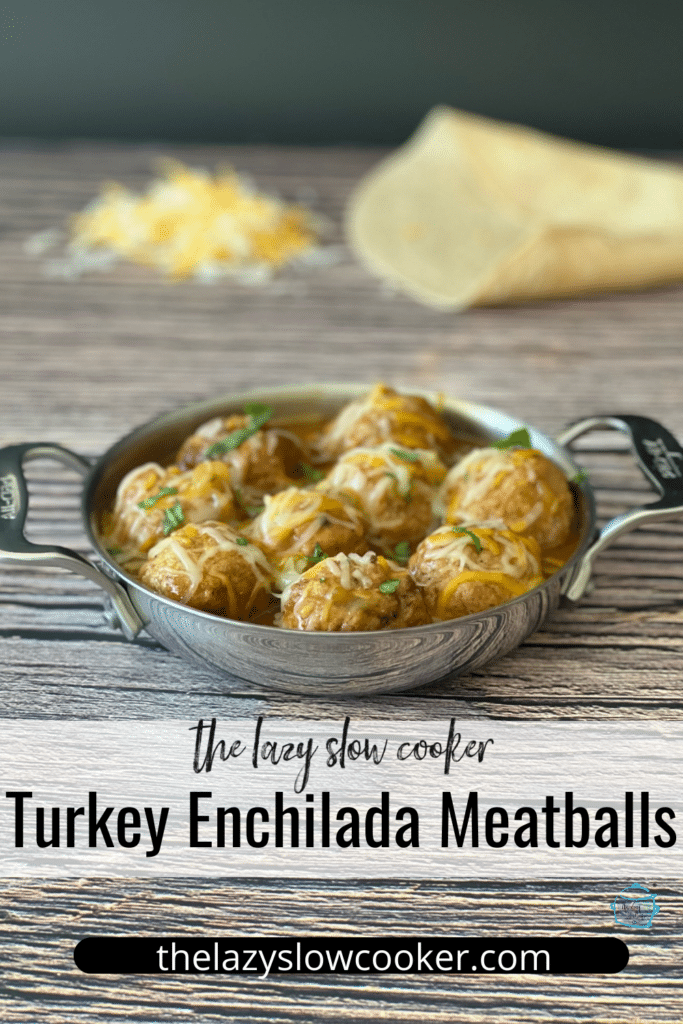 a round metal pan filled with creamy turkey enchiladameatballs topped with cheese