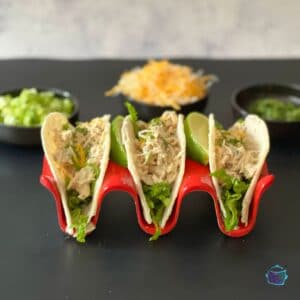 a side view of three soft taco shells filled with creamy salsa