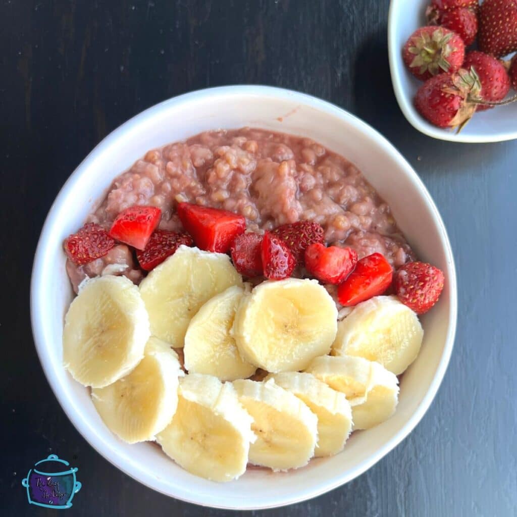 looking down on a bowl of oatmeal topped with fresh strawberries & bananas
