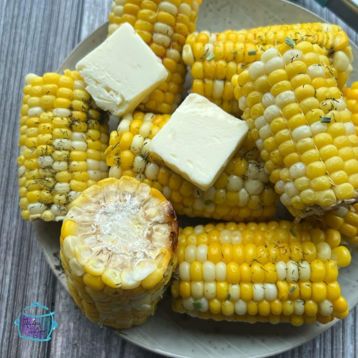 cooked corn out of the crockpot with some pats of butter on top