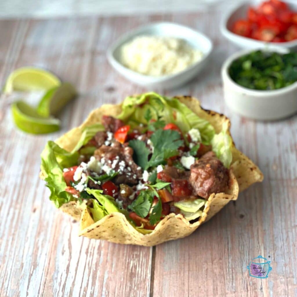 side view of crockpot carne picada in a taco bowl