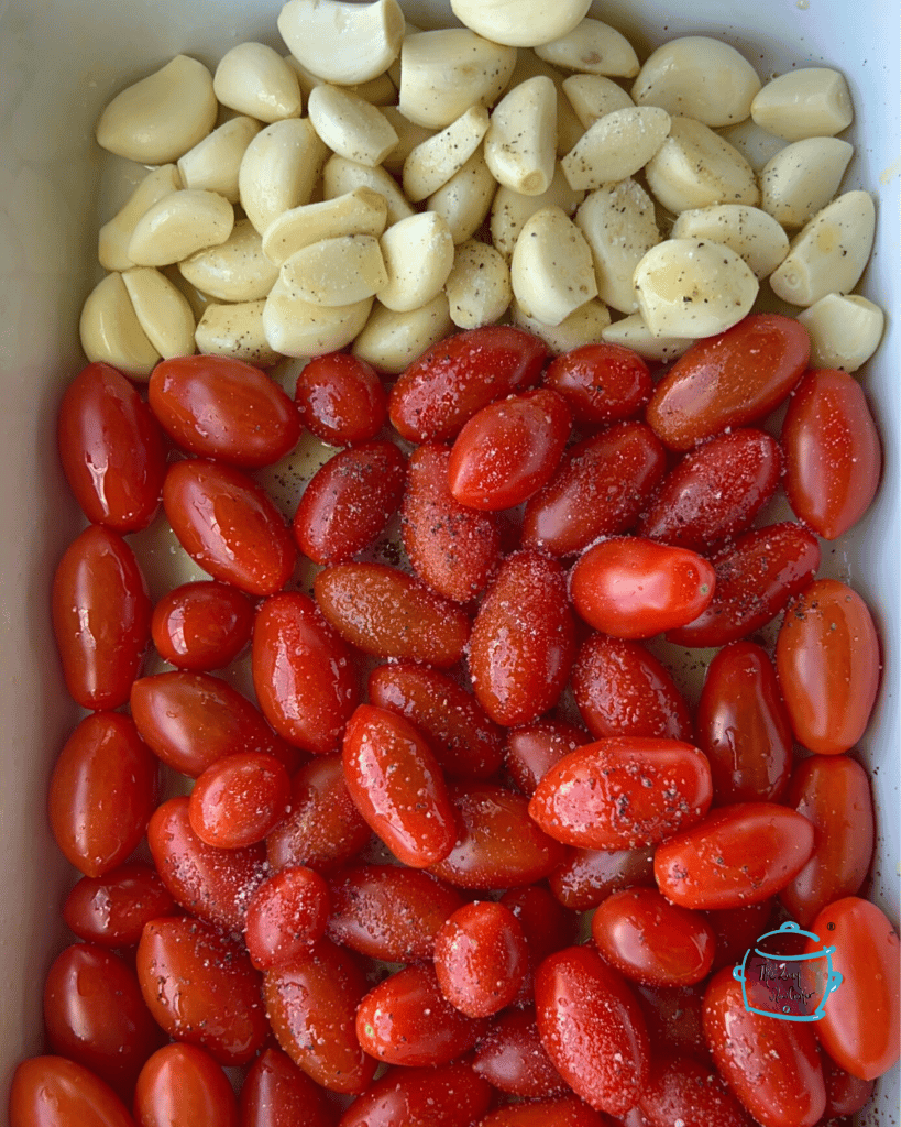 grape tomatoes and garlic cloves in slow cooker before cooking