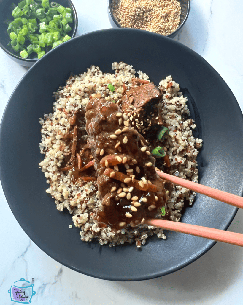 Beef bulgogi after slow cooking, held by chop sticks