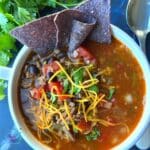 look down on a bowl of slow cooker taco soup topped with shredded cheese