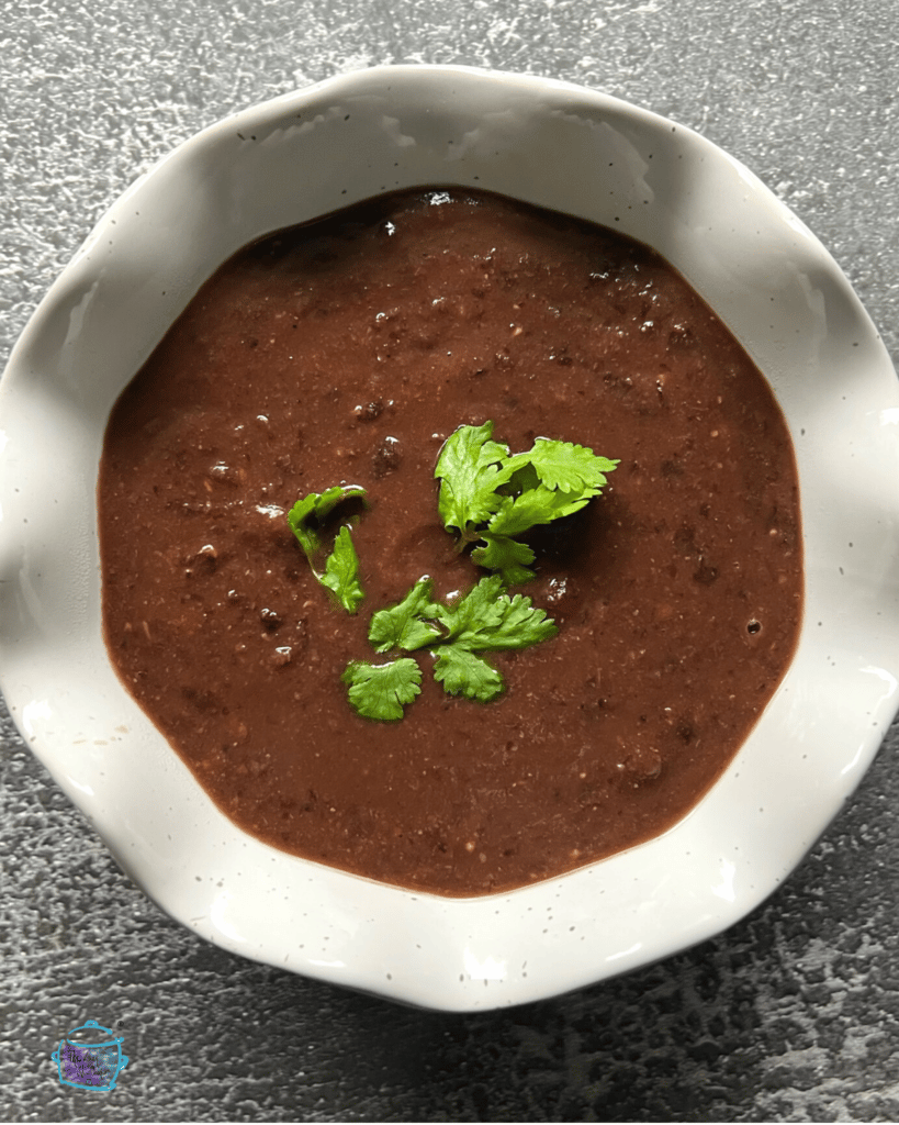 a bowl full of crockpot black bean soup in a bowl ready to serve