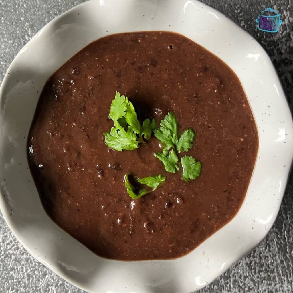 a bowl full of crockpot black bean soup in a bowl ready to serve
