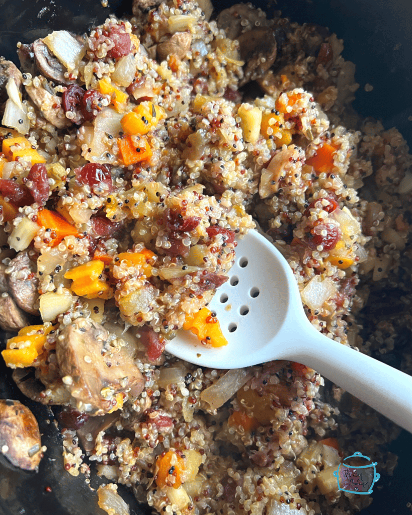 a slow cooker full of finished quinoa stuffing with some on a spoon