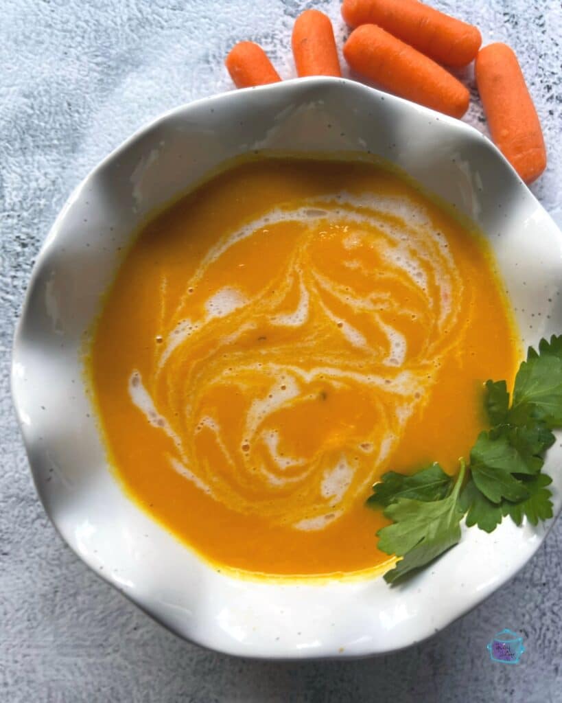 looking down on a bowl of carrot ginger soup with coconut cream