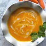 looking down on a bowl of carrot ginger soup with coconut cream