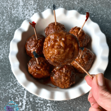 a bowl with honey bourbon crockpot meatballs on toothpicks