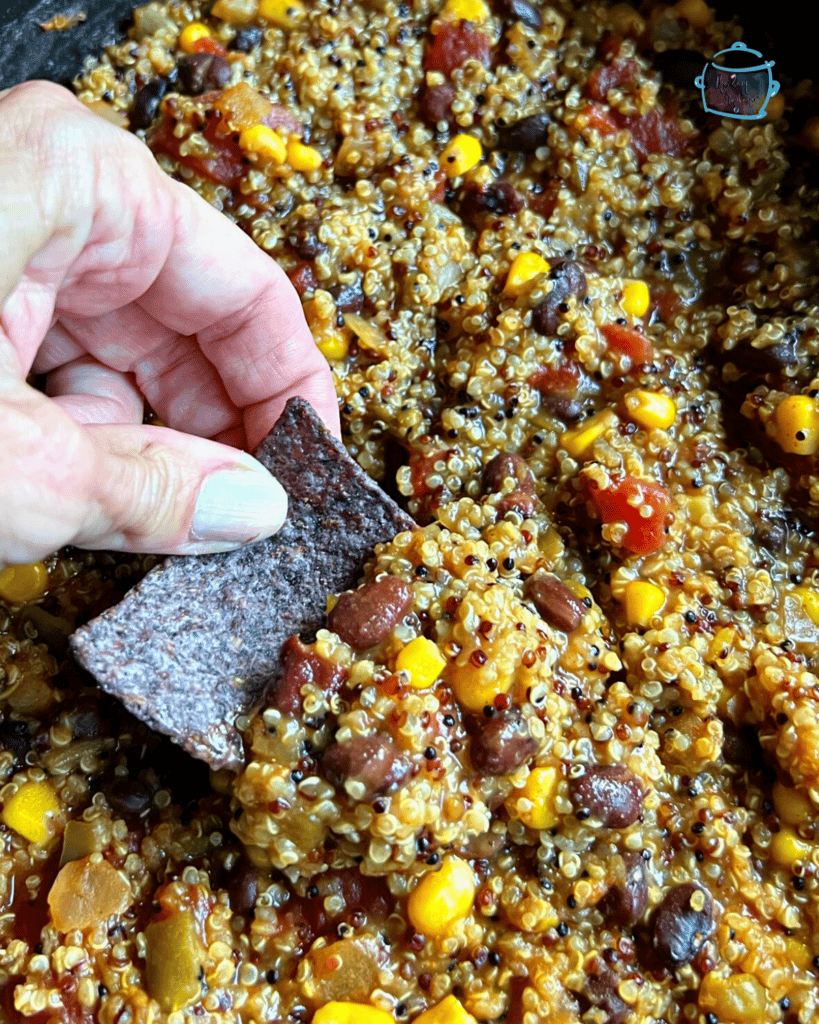 slow cooker quinoa being scooped up into a tortilla chip