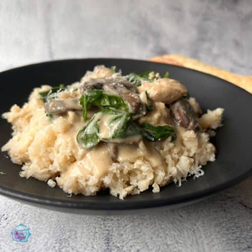 side view of a plate holding slow cooker garlic parmesan chicken over cauliflower rice
