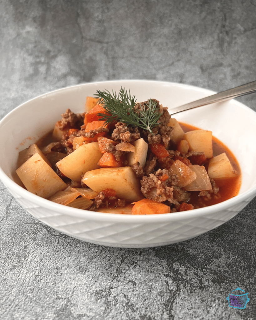 a bowl of crockpot ground beef stew with a spoon