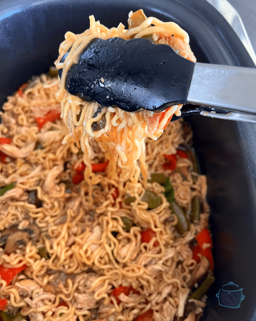 chicken ramen after slow cooker being served with tongs