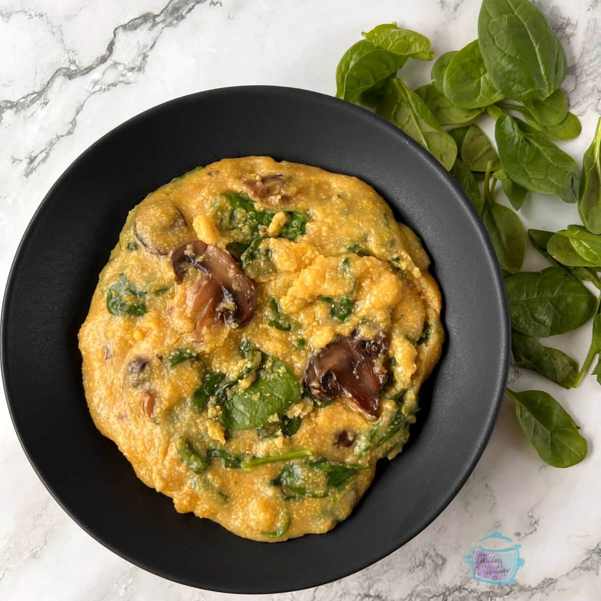 looking down on a bowl of slow cooker polenta with mushrooms and spinach