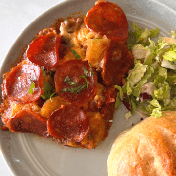 crustless pizza that was cooked in a crockpot on a white plate with a fork and roll