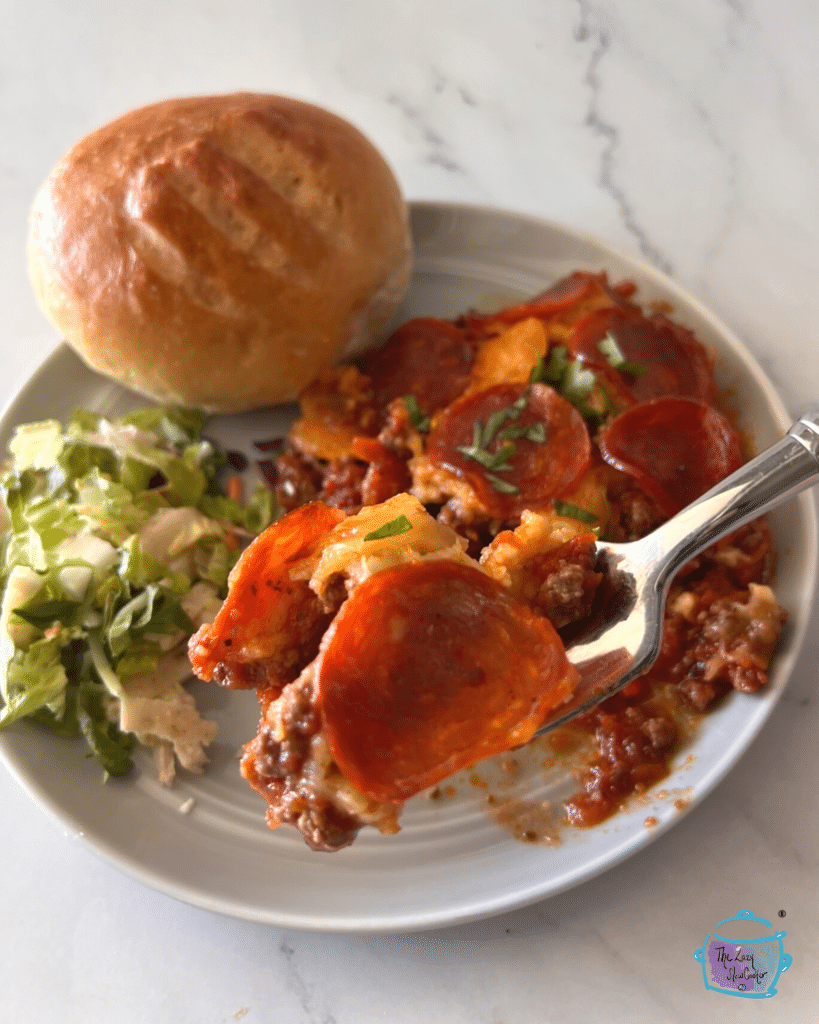 crustless pizza that was cooked in a crockpot on a white plate with a fork and roll