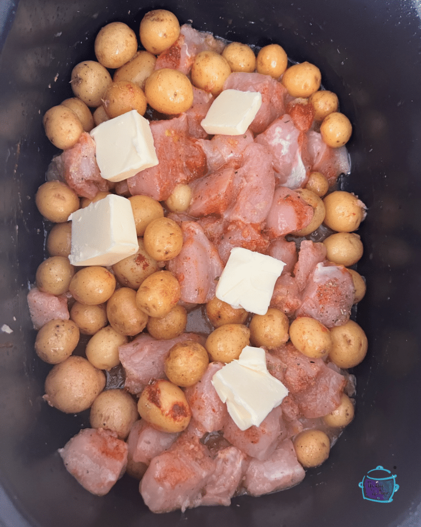 chicken potatoes, lemon, butter garlic and other spiced in slow cooker prior to cooking