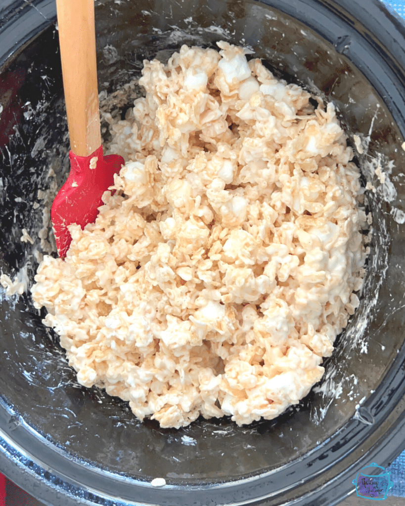 rice cereal and marshmallows in slow cooking being mixed togehter