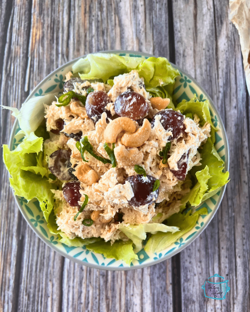 chicken salad that was initially cooked in a crockpot in a bowl lined with lettuce.
