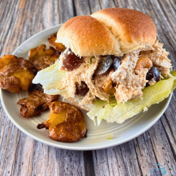 chicken salad sandwich with crispy smashed potatoes on the side.