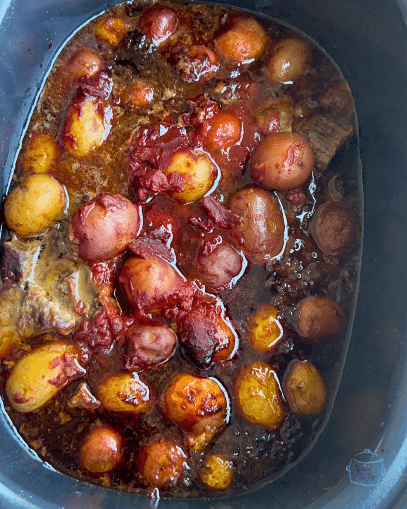 Cooked steak bites and potatoes in a crockpot before serving