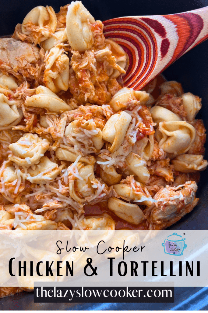 Shredded chicken and tortellini in a slow cooker with a wooden spoon.
