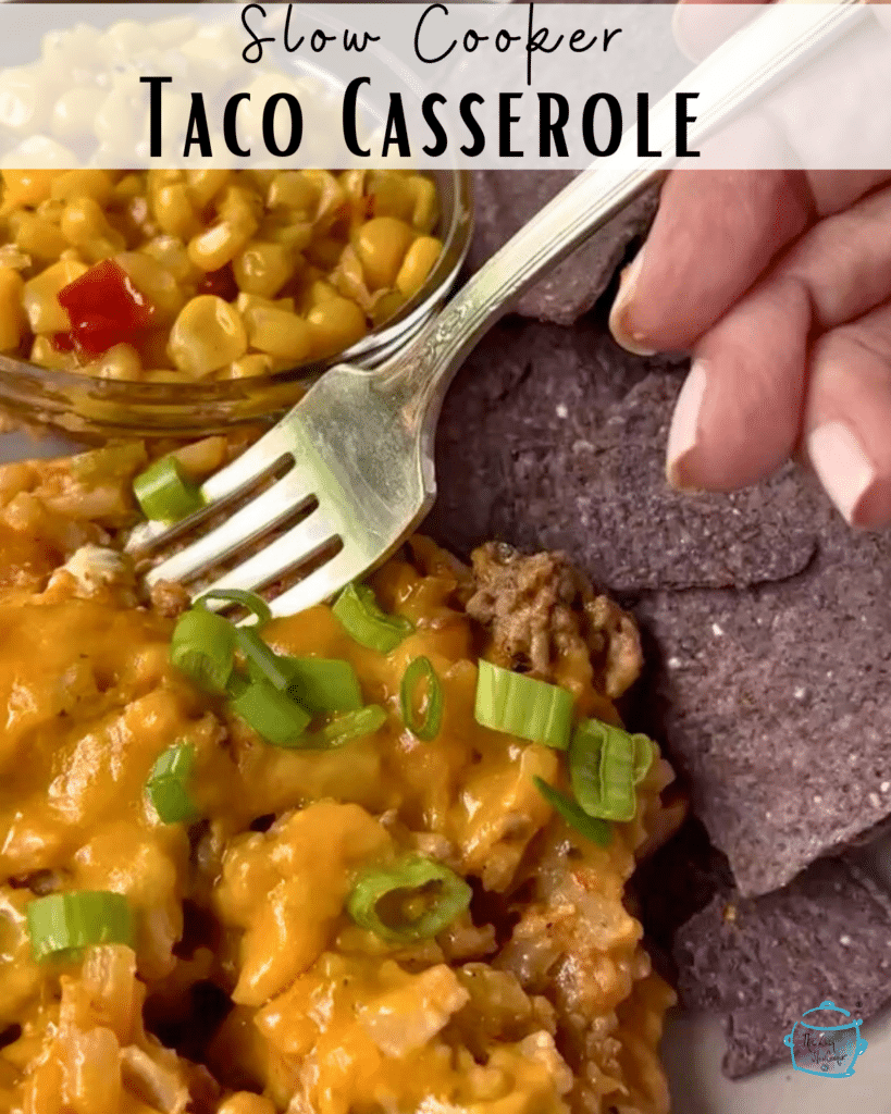 taco potato casserole on a plate with chips, corn and a fork