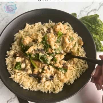 Slow cooker turkey spinach and pepper jack cheese casserole in a black bowl with a fork