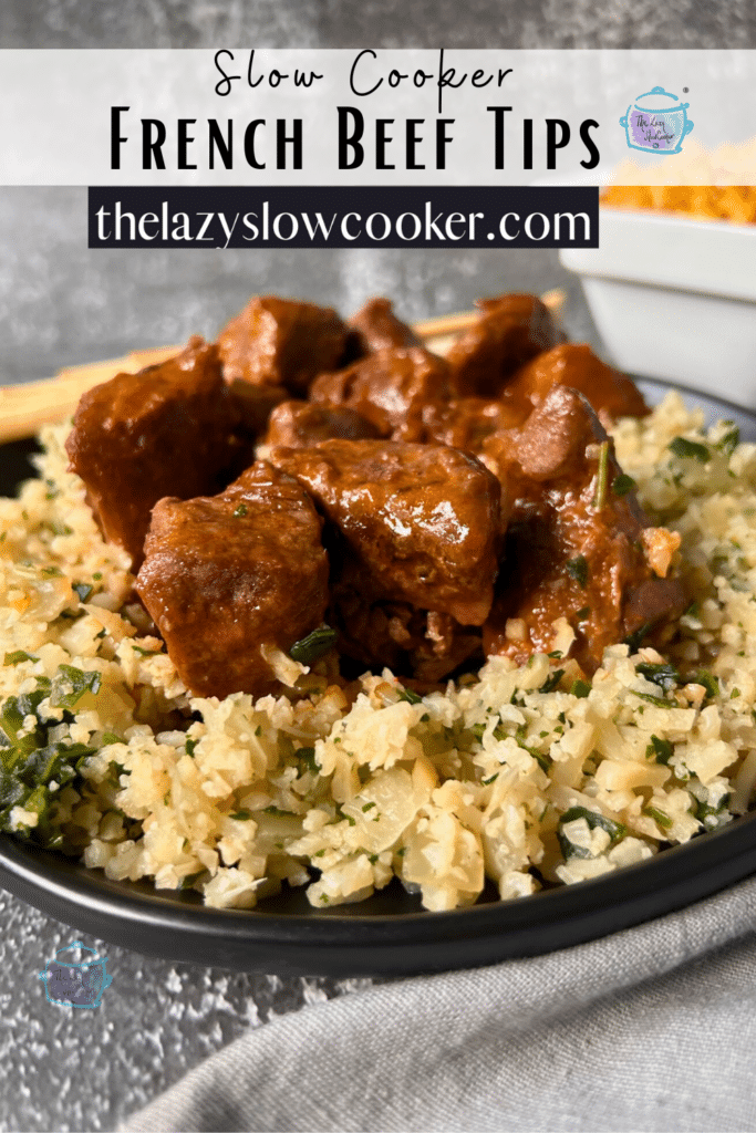 Chunks of sauce covered beef on a plate of riced cauliflower and broccoli.
