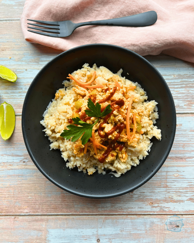 Slow cooked sweet chili ground turkey in a bowl on a bed of riced cauliflower.