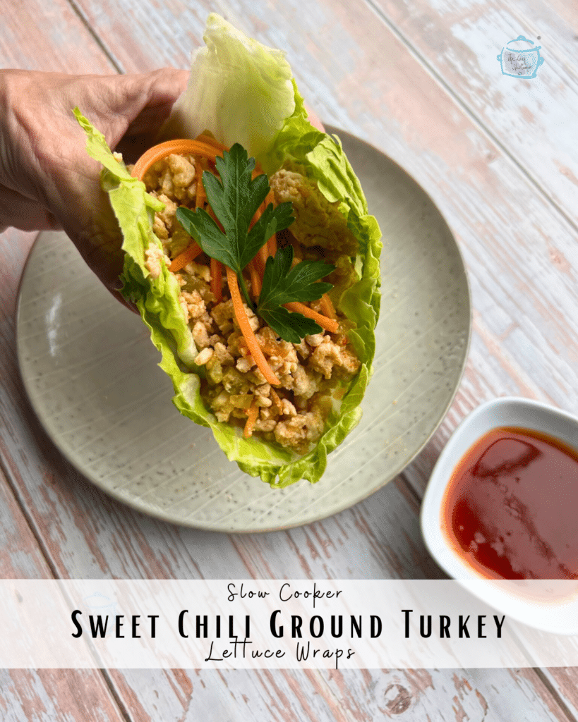 Slow cooker ground turkey in a lettuce leaf held in a hand.