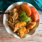 balsamic peach slow cooker chicken in a white bowl with a fork