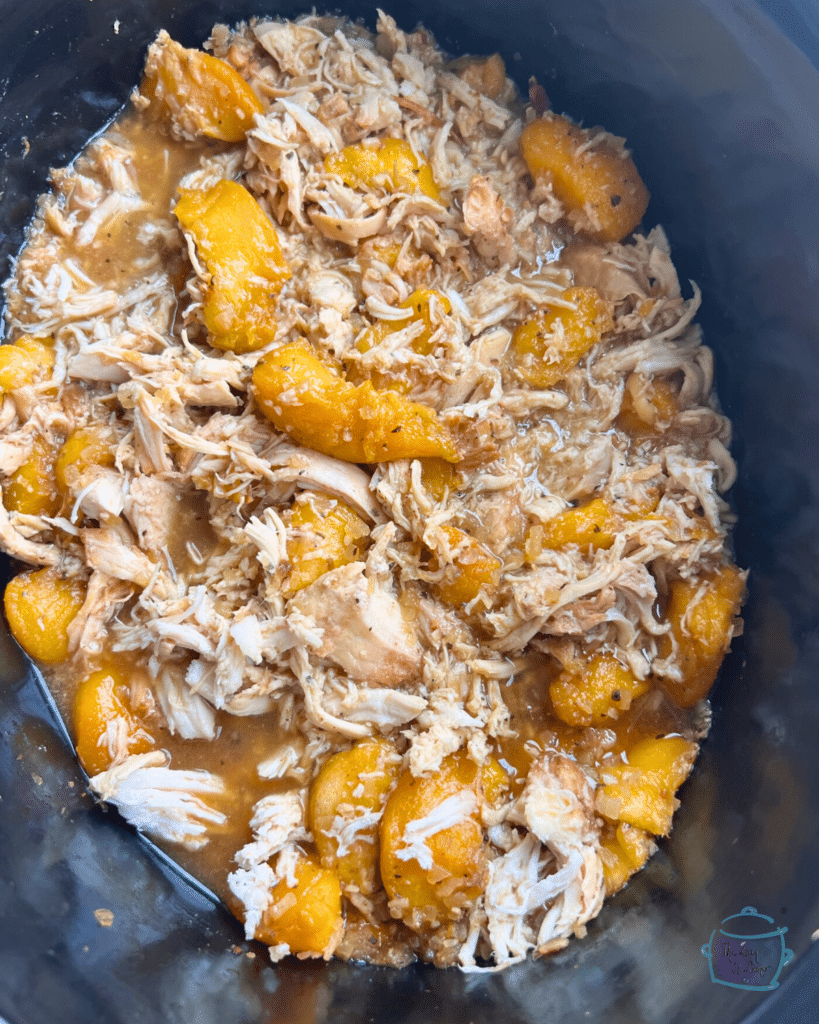 shredded chicken and peaches in a slow cooker