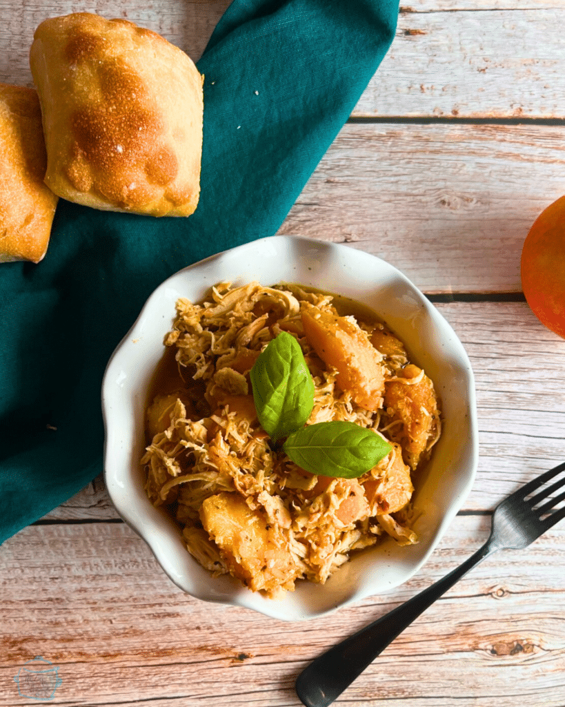 balsamic peach slow cooker chicken in a white bowl with a fork