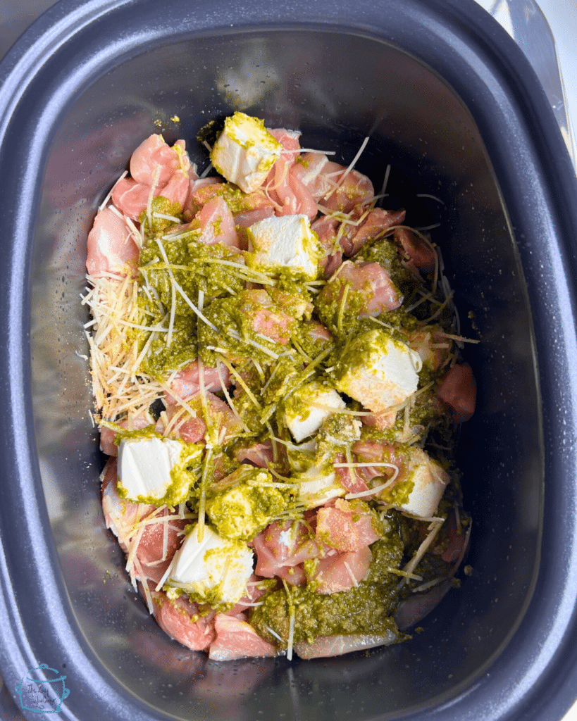 pesto chicken ingredients in a crockpot before cooking