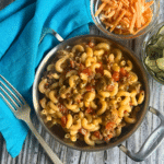 beefy and tomatoey macaroni with cheese in a metal pot with two handles