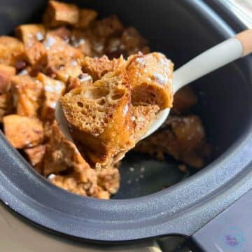 gingerbread French toast casserole on a spoon held over a slow cooker